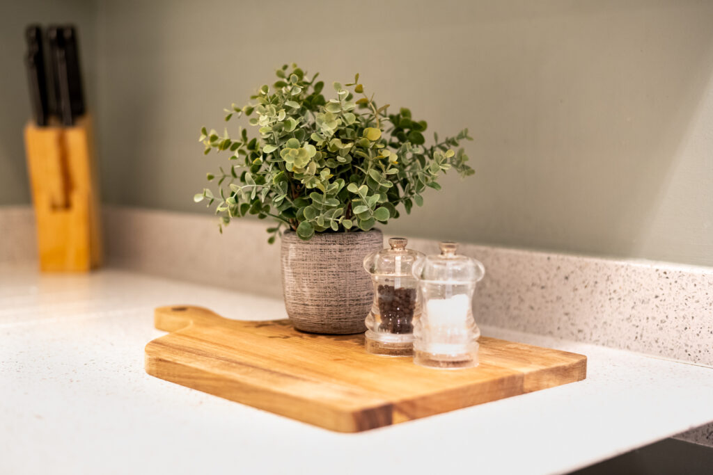 chopping board with potted plant and salt and pepper shakers